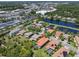 Aerial view of houses with private pools and well-maintained lawns near a highway and lake in a suburban neighborhood at 2671 Lakebreeze S Ln, Clearwater, FL 33759