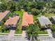 A beautiful aerial view of a home with a red tile roof, pool, and lush landscaping in a suburban neighborhood at 2671 Lakebreeze S Ln, Clearwater, FL 33759