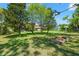 Expansive backyard features lush green grass, mature trees, and a garden area perfect for outdoor enjoyment at 2671 Lakebreeze S Ln, Clearwater, FL 33759