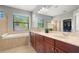 Bathroom with double sinks, bathtub, large mirror, and walk-in shower at 2671 Lakebreeze S Ln, Clearwater, FL 33759