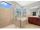 Bright bathroom featuring a walk-in shower, bathtub, and double windows at 2671 Lakebreeze S Ln, Clearwater, FL 33759