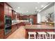 Large kitchen with center island, breakfast bar, stainless appliances and warm wood at 2671 Lakebreeze S Ln, Clearwater, FL 33759