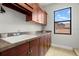 Functional laundry room with ample counter space, cabinets, and a window overlooking the exterior at 2671 Lakebreeze S Ln, Clearwater, FL 33759