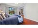 Comfortable bedroom with wood floors features a ceiling fan and backyard pool access at 2671 Lakebreeze S Ln, Clearwater, FL 33759