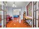 Well-lit office with hardwood floors showcasing the desk, seating, and entryway into the bedroom at 2671 Lakebreeze S Ln, Clearwater, FL 33759