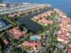 Aerial view of waterfront condos with red tile roofs, a community pool, and boat docks at 2741 Via Cipriani # 931A, Clearwater, FL 33764