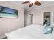 Comfortable bedroom with a ceiling fan, TV, and a view into the walk-in closet and bathroom at 2741 Via Cipriani # 931A, Clearwater, FL 33764