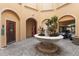 A tranquil courtyard space features an ornate fountain surrounded by lush greenery, a sauna and space for golf cart parking at 2741 Via Cipriani # 931A, Clearwater, FL 33764