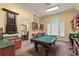 A recreation space includes a pool table, seating area and custom cabinet for game storage at 2741 Via Cipriani # 931A, Clearwater, FL 33764