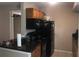 Functional kitchen with black appliances, granite counters, and ample cabinet space at 3206 W Azeele St # 226, Tampa, FL 33609