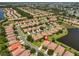 Aerial view of a large Del Webb neighborhood with homes surrounding a pond and views of the ocean in the distance at 336 Silver Falls Dr, Apollo Beach, FL 33572