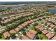 Real estate aerial view of a home with an orange roof surrounded by similar homes and a nearby lake at 336 Silver Falls Dr, Apollo Beach, FL 33572