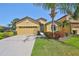 Charming single-story home with yellow facade, well-manicured lawn, and a two-car garage at 336 Silver Falls Dr, Apollo Beach, FL 33572