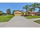 Inviting yellow home with a well-kept lawn and a long driveway, creating a welcoming curb appeal at 336 Silver Falls Dr, Apollo Beach, FL 33572