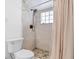Tiled bathroom featuring a shower with pebble flooring and glass block window for natural light at 3654 Warbler Dr, New Port Richey, FL 34652