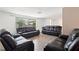 Bright living room with leather couches, tiled floors and a view to the outside at 3654 Warbler Dr, New Port Richey, FL 34652
