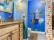 Bathroom with unique blue walls decorated with colorful sea life paintings at 402 S Barbara Ln, Tampa, FL 33609