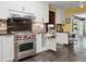 Modern kitchen with stainless steel stove, range hood, custom cabinets and tile backsplash at 402 S Barbara Ln, Tampa, FL 33609