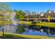 Modern townhomes overlook a scenic pond with fountain and rainbow, surrounded by lush landscaping on a clear day at 4118 Gauge Line Loop, Tampa, FL 33624