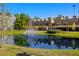 Beautiful exterior view of condo buildings by a pond with fountain and lush landscaping at 4118 Gauge Line Loop, Tampa, FL 33624