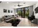 Bright, modern living room featuring a gray sofa, large windows with backyard view, and stylish black accents at 4118 Gauge Line Loop, Tampa, FL 33624