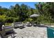 Relaxing pool patio featuring comfortable lounge seating, dining area, and mature trees at 4118 Gauge Line Loop, Tampa, FL 33624