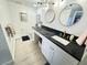 Bright bathroom with white cabinets, dual sinks, and a black countertop at 4141 Bayshore Blvd # 1103, Tampa, FL 33611