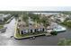 Wide aerial shot of canal-front condos featuring community pool and boat docks, surrounded by lush greenery at 428 Moorings Cove Dr # 7F, Tarpon Springs, FL 34689