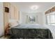 Cozy bedroom with a large bed, bright window, and unique wall decorations at 428 Moorings Cove Dr # 7F, Tarpon Springs, FL 34689