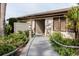 Inviting clubhouse entrance with a quaint wooden walkway, lush greenery, and a warm, welcoming ambiance at 428 Moorings Cove Dr # 7F, Tarpon Springs, FL 34689