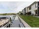 Exterior featuring a private dock along the waterfront with boat, buildings and grassy lawn at 428 Moorings Cove Dr # 7F, Tarpon Springs, FL 34689