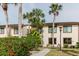 Front exterior view of the condo showcasing the well-maintained landscaping and palm trees at 428 Moorings Cove Dr # 7F, Tarpon Springs, FL 34689
