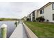 Exterior featuring a private dock along the waterfront with boat mooring and grassy lawn at 428 Moorings Cove Dr # 7F, Tarpon Springs, FL 34689