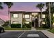 Inviting two-story condo with lush landscaping and palm trees, set against a colorful twilight sky at 428 Moorings Cove Dr # 7F, Tarpon Springs, FL 34689