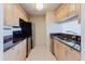 Efficient kitchen with light wood cabinets, stainless appliances, and solid surface countertops at 428 Moorings Cove Dr # 7F, Tarpon Springs, FL 34689