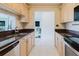 Well-lit kitchen boasts light wood cabinets, double bowl sink, and view to another room at 428 Moorings Cove Dr # 7F, Tarpon Springs, FL 34689