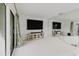 Spacious living room featuring a large flat-screen TV, sliding glass doors, and accent wall mirror at 428 Moorings Cove Dr # 7F, Tarpon Springs, FL 34689