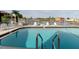 Community pool area showcasing crystal-clear water, comfortable seating, and a serene waterfront ambiance for relaxation at 428 Moorings Cove Dr # 7F, Tarpon Springs, FL 34689