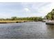 Waterfront view of tranquil canal with grassy banks, docks, and mature trees enhancing privacy at 428 Moorings Cove Dr # 7F, Tarpon Springs, FL 34689