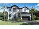 Beautiful two-story home featuring a stone facade and modern black trim, complemented by lush landscaping and a paved driveway at 4618 W Kensington Ave, Tampa, FL 33629