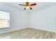 Clean bedroom featuring a ceiling fan, neutral paint, wood-look floors, and a bright window at 538 Summer Sails Dr, Valrico, FL 33594