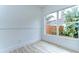 Bright room featuring neutral paint, wood-look floors, and a large window showcasing lush greenery at 538 Summer Sails Dr, Valrico, FL 33594
