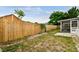 Fenced backyard with sparse grass leads to a screened in porch area at 5810 8Th Ave, New Port Richey, FL 34652