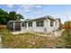 Backyard with a screened-in patio, stone floor, partial fence, and exterior building features at 5810 8Th Ave, New Port Richey, FL 34652