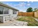 A partially grassy fenced backyard featuring a concrete patio and a small utility structure at 5810 8Th Ave, New Port Richey, FL 34652