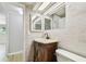 Updated bathroom featuring a wood vanity, modern faucet, marble counters, and updated tile flooring at 5810 8Th Ave, New Port Richey, FL 34652