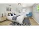 Bright bedroom with neutral walls, a black-and-white rug, and a comfortable bed and chair at 5810 8Th Ave, New Port Richey, FL 34652