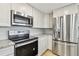 Close-up of kitchen with stainless steel appliances, white cabinets and granite countertops at 5810 8Th Ave, New Port Richey, FL 34652