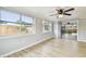 Living room featuring two windows, wood flooring, modern ceiling fan, and sliding glass doors to a patio at 5810 8Th Ave, New Port Richey, FL 34652