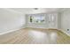 Living room featuring hardwood floors and natural light from a large window at 5810 8Th Ave, New Port Richey, FL 34652